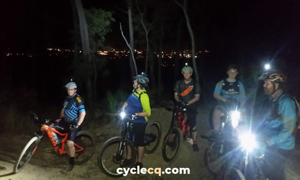 Social mountain bike night ride at First Turkey MTB Reserve with Rockhampton city lights in the distance.